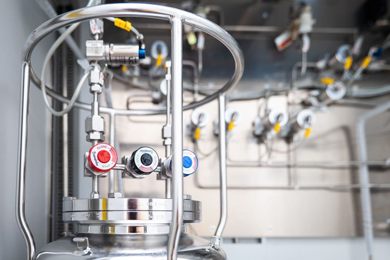 Stainless-steel precursor cylinder with valves inside the ALD coating platform.